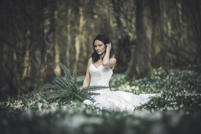 Bride posing in the woods at the Dreys