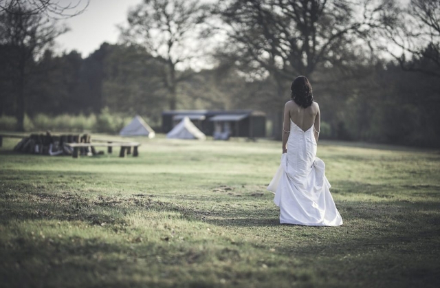 Bride walking across the meadow at the Dreys