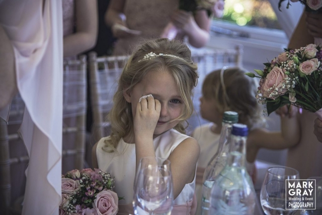 Flower girl wiping away tears as wedding becomes emotional
