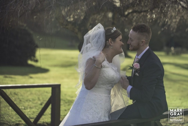 Bride and groom relax in the the grounds at Chilston Park Hotel