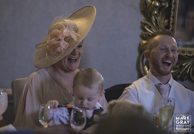 Bride`s mum and groom laughing at speech